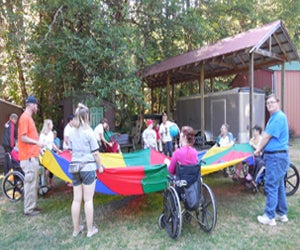 Several campers playing a game together, using a parachute