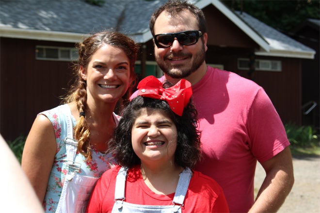 Camper and her family smiling, in the sun