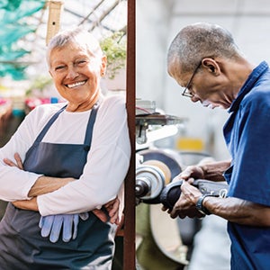 Gray-haired woman smiling, next to man with his back-turned, working