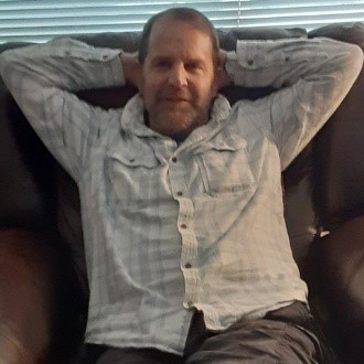 Army Veteran, Mr. S. relaxing in a leather recliner that he received as a part of his 