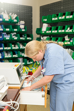 A woman working in a medical supply storage area