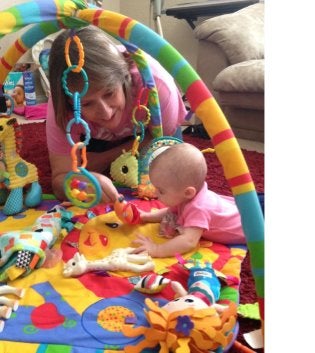 Child with therapist working on tummy time.