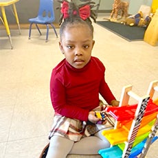 girl playing with brightly colored toy