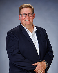 White male with glasses smiling