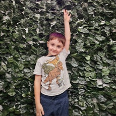 boy with one arm up in the air and smiling