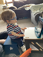 Boy with glasses in front of iPad