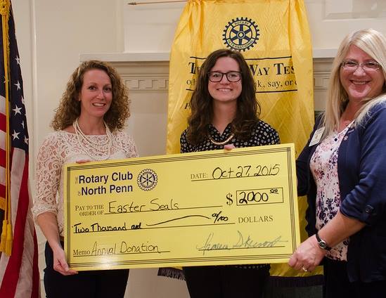 three women holding an oversizerd check from Rotary to Easterseals
