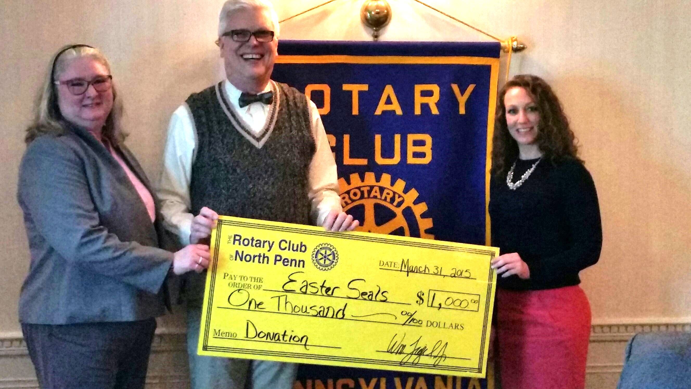 two women and a man hold an oversized check from North Penn Rotary to Easterseals
