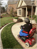 Woman in a scooter entering an accessible home