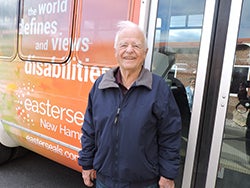 An elderly man standing next to an Easterseals transportation vehicle