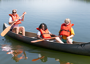 Two campers and a counselor on a canoe
