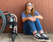 Rachelle Chapman sitting down on the ground next to her wheelchair