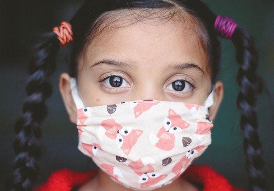 Young girl with braids wearing a face mask