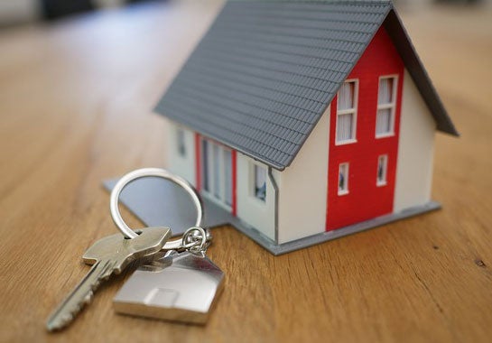 A model of a house with a set of keys