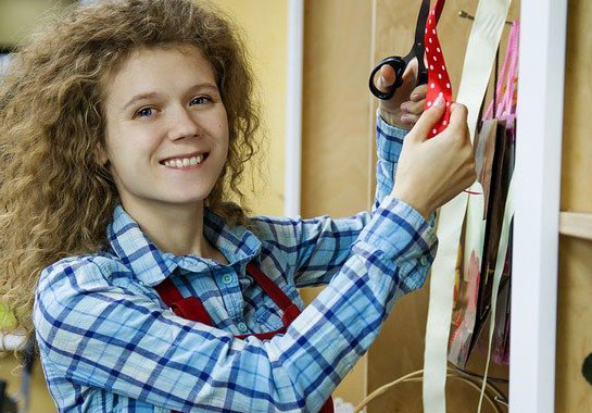 Young Woman Working holding fabric scissors