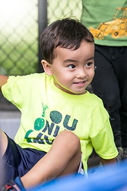 A young boy (about 5 or 6) playing outside on a playground