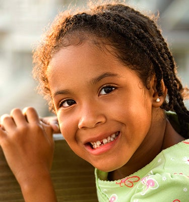 young girl smiling in front of computer