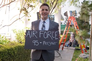 Jose smiling and holding a sign that reads: Air Force 95 - present