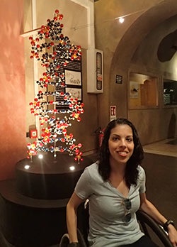 Kelley sits in front of a model of a molecular structure