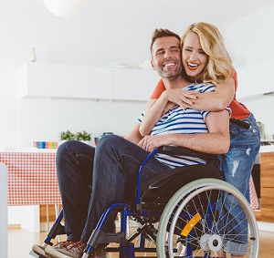 A woman hugging a man in a wheelchair