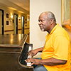 An elderly man playing the piano