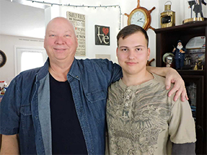 Mike (left) and his son Alex (right) stand smiling