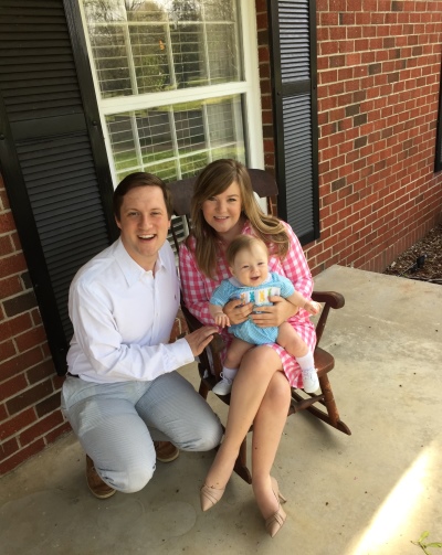 Palmer Williams, her husband and baby boy sitting on new front porch