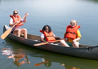 Two campers and a counselor on a canoe