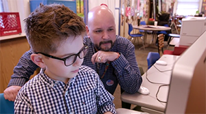 Charlie and Scott sit at a computer