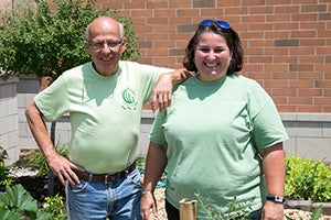 A camper and volunteer planting a tree.