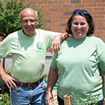 Two volunteers wearing green shirts