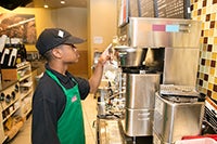 A teenager working in a coffee shop