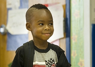 Young boy at school with backpack on