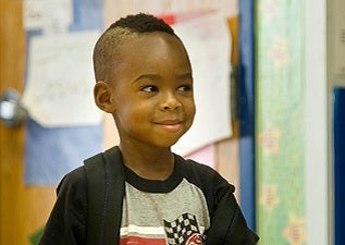 Young boy at school with backpack on