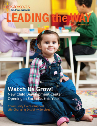 A cover image for the 2023 Spring Advancement Newsletter of a toddler in a classroom smiling for the camera