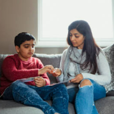 A indian mom and son using an AAC tablet 