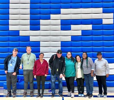 Easterseals participants standing together in the Cerritos College basketball gym. 