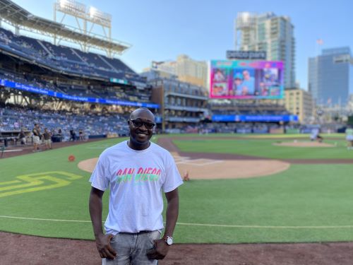 A man in a white shirt stands on the field at the San Diego Padres Stadium