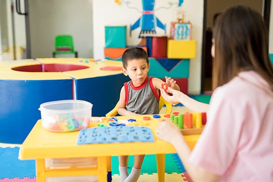 Kid practicing pronuncation with therapist