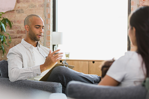Therapist in a chair talking to client sitting across