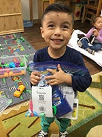 Boy from CDC holding bag of CVS-donated school Supplies