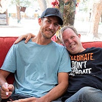 A male camper and volunteer pose for the camera