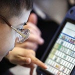 Male in glasses using computer touchscreen