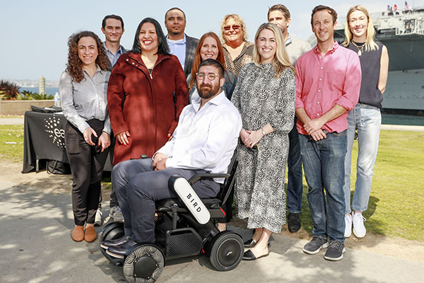 Group photo of Easterseas and Bird representatives in front of Veteran Nick Voss in Bird Power Wheelchair
