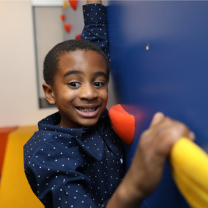 A photo of former Autism Therapy Services participant, Ethan wearing a blue button up smiling for a photo.