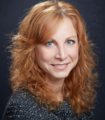 A white woman with ginger hair smiling for her headshot
