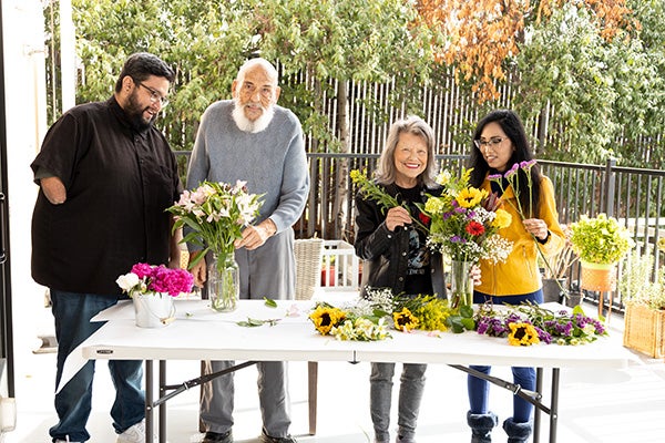 Linda and three other people arranging flowers.