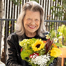 Photo of Linda with a bouquet of flowers