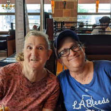 Two peer to peer participants Pearl and Amy sitting at a restaurant and posing for a photo