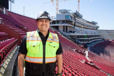 A Veteran in a construction hat standing in a stadium
